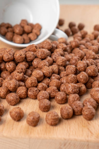 istock Crunchy chocolate cereal with white cup. Textured flakes balls 1316601754