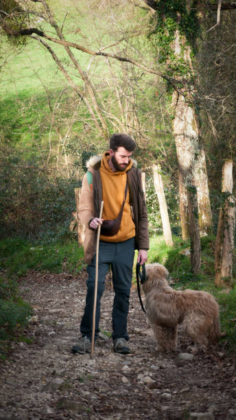 istock Bearded man and dog in the woods 1316602312