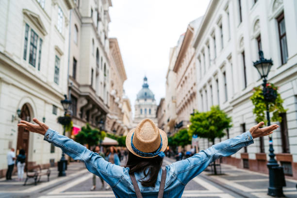 mulher parada com os braços estendidos na rua budapeste - city break - fotografias e filmes do acervo