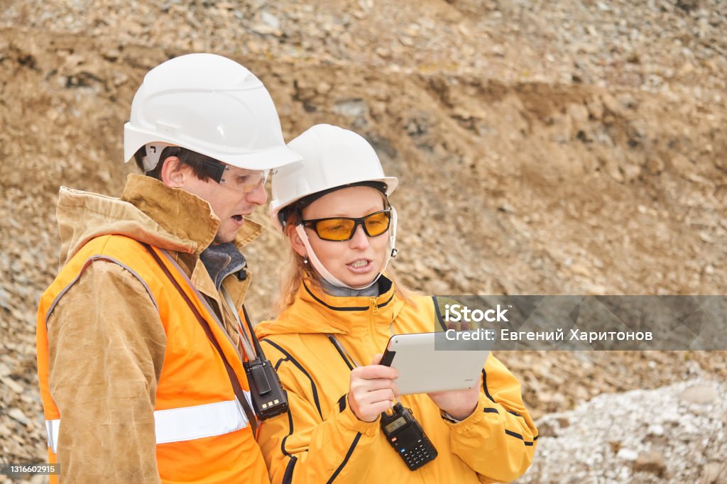 mining engineers discussing working documentation at the mining site mining engineers discussing working documentation outdoor at the mining site Geologist Stock Photo