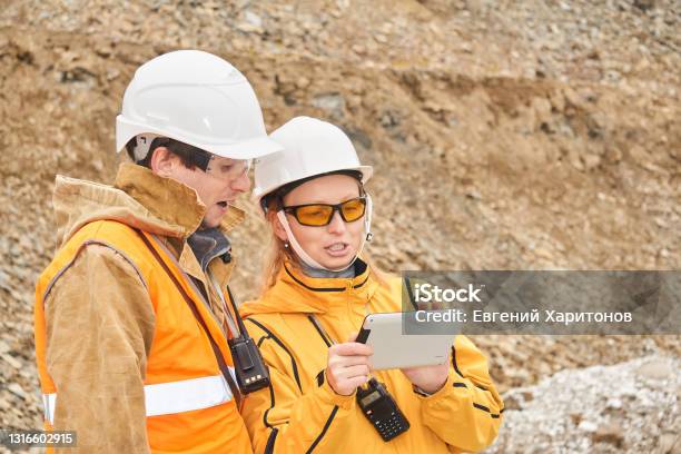 Mining Engineers Discussing Working Documentation At The Mining Site Stock Photo - Download Image Now