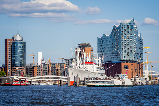 skyline of the hafencity in hamburg with view to the überseebrücke with a famous old freighter and the elbphilharmonie concert hall in the background