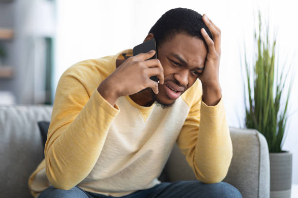 istock Closeup of sad black guy having conversation on phone 1316604227