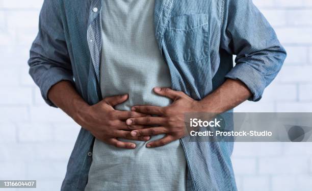 Black Guy Touching Aching Abdomen Having Stomachache Gray Background Cropped Stock Photo - Download Image Now