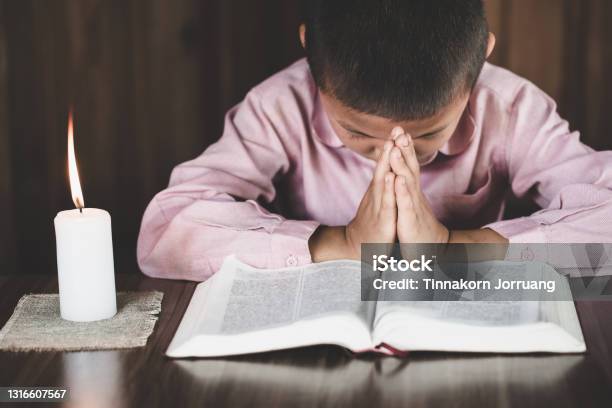 Boy Praying To God Hands Folded In Prayer Concept For Faithspirituality And Religion Stock Photo - Download Image Now
