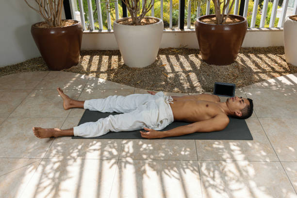 istock Young Brazilian man doing online yoga class, in the corpse pose position. 1316607867