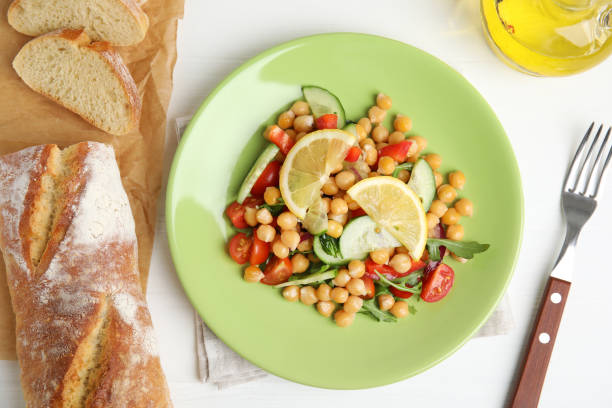 istock Delicious fresh chickpea salad served on white wooden table, flat lay 1316609340