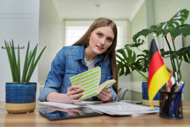 istock Female student looking talking to webcam, studying German online 1316611223