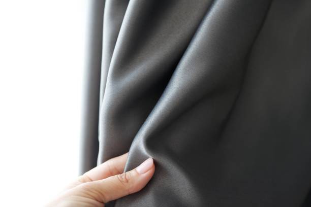 istock Woman's hand touching curtain, gray blackout fabric, light-blocking fabric 1316611844