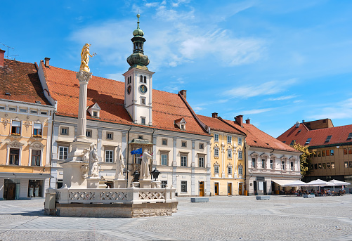 Maribor city center, Slovenia. Town Hall and Plague Monument on the Maribor Main Square. Blue sky, bright daylight, cityscape, tourist destination in Europe.