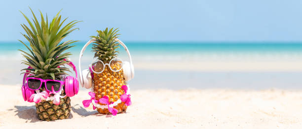 l’été à la fête.  mode hipster d’ananas dans le verre de soleil et écoutez la musique sur le fond bleu de ciel de plage de sable - romantic sky audio photos et images de collection