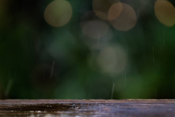 Light rain on wooden table with dark defocus background.