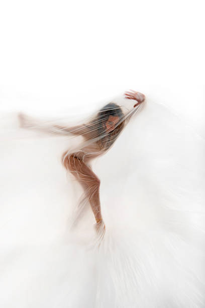 Beautiful ballerina is dancing with thin nylon