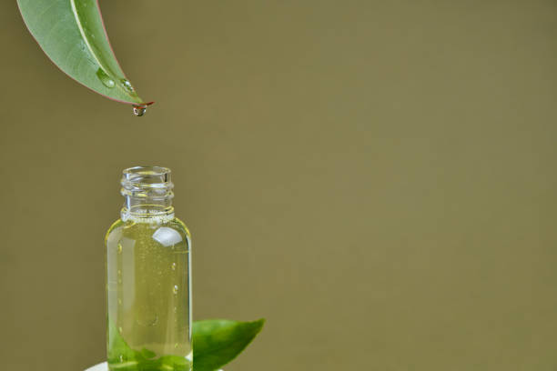 istock essential oil dripping from leaf into glass bottle isolated on beige 1316623574