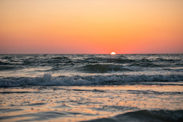 The sun sets over the horizon on the beach in Clearwater, Florida