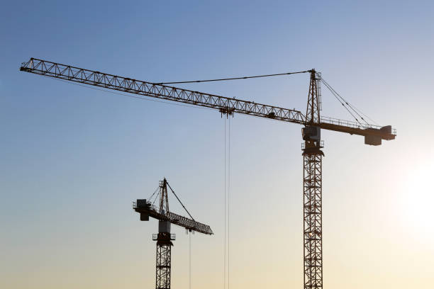 istock Silhouettes of construction cranes on blue sky and sunrise background 1316629681