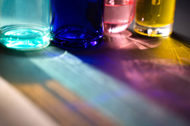 Blue turquoise pink and yellow glass bottles and reflections in harsh light. Beauty products in a new light.