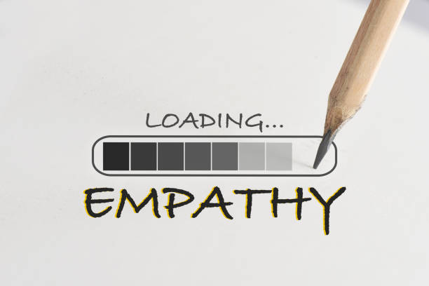 Empathy loading written on white paper with processing symbol and pencil stock photo