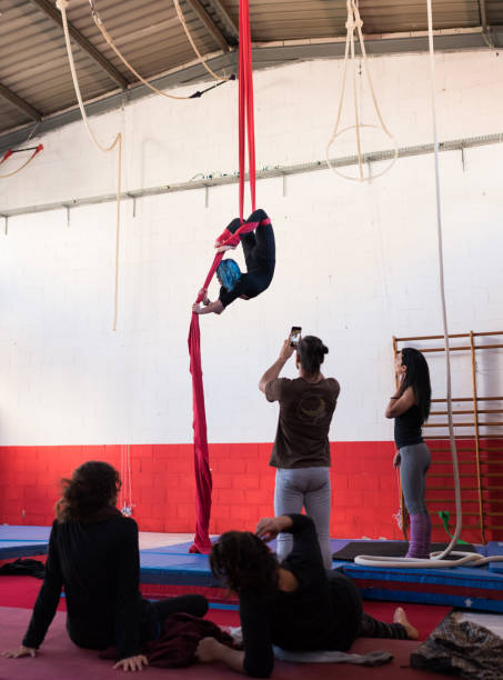 Woman training on aerial silks in group