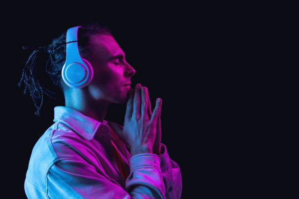 istock One Caucasian young man isolated on dark studio background in neon. Side view 1316632750