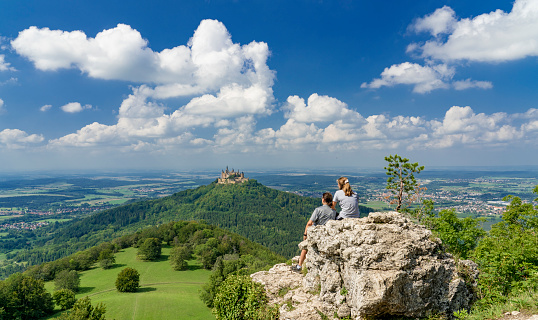 Hohenzollern castle, Baden-Württemberg,Germany - 06-07-2020, two women admiring  one of the most famous landmarks in Baden-Württemberg and main castle of Hohenzollern dynasty, during a hike on the swabian alb