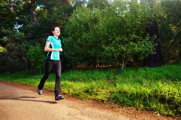 istock Young female runner exercising in a beautiful sunny forest 1316637769