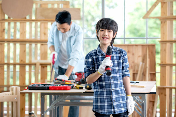 istock Asian boy hold electric drill and smile with look at camera 1316641082