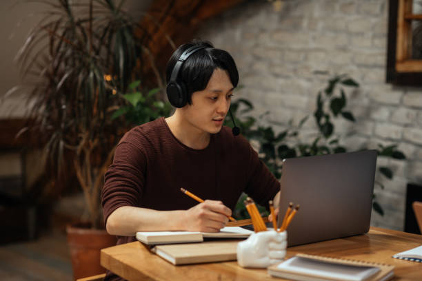 istock Asian man working at home with earphones on 1316641172