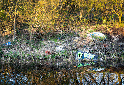 Various types of litter washed up on the riverbanks of a British waterway.