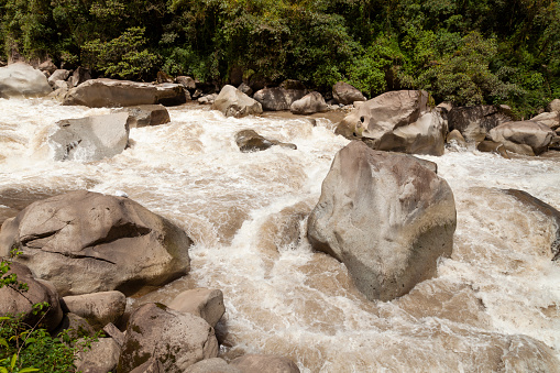 Turbulent waters of the Urubamba or Vilcanota river, crossing the Amazon cloud forest, as it passes through the town of Aguas Calientes, near Machu Picchu, Sacred Valley of the Incas, Peru.