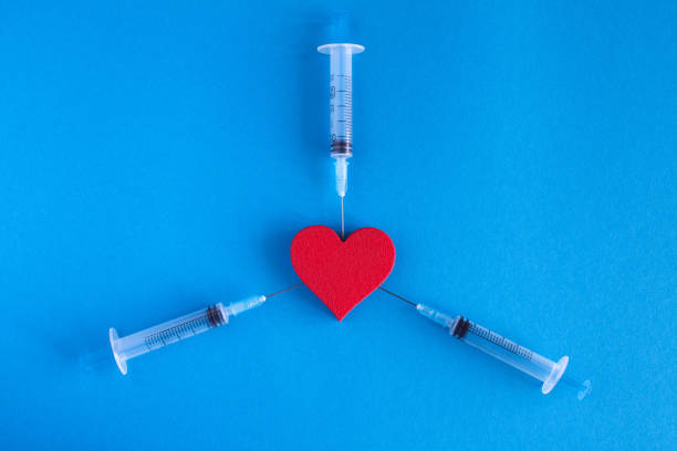 istock Red heart and syringes on the blue  background.Top view.Copy space. 1316649159