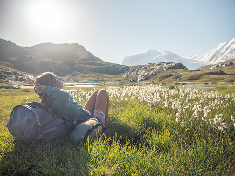 View of woman relaxing on mountain trail near alpine lake, Switzerland