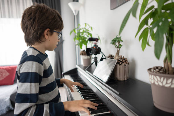 istock Young boy musician playing piano and vlogging 1316650683