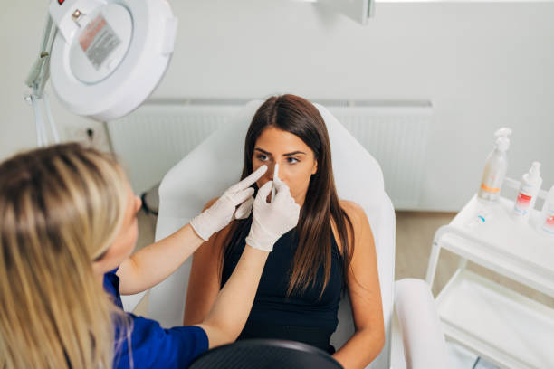 plastic surgeon, observing the client face and sketch the lines where she planning to do the nose job - nose job imagens e fotografias de stock