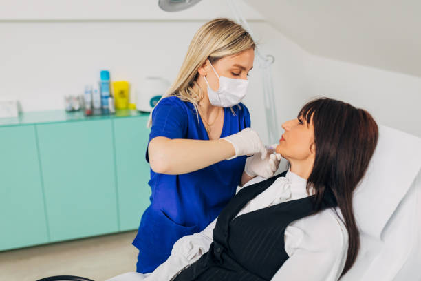 istock Dedicated beautician, using botox to reduce the wrinkles on her modern and elegant mature female client 1316653047