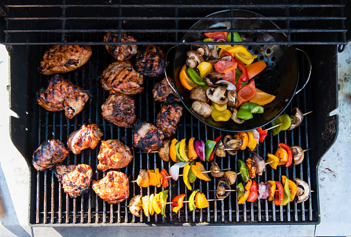 Overhead of vegetable skewers and chicken on the grill of a gas bbq. in Kingston, ON, Canada
