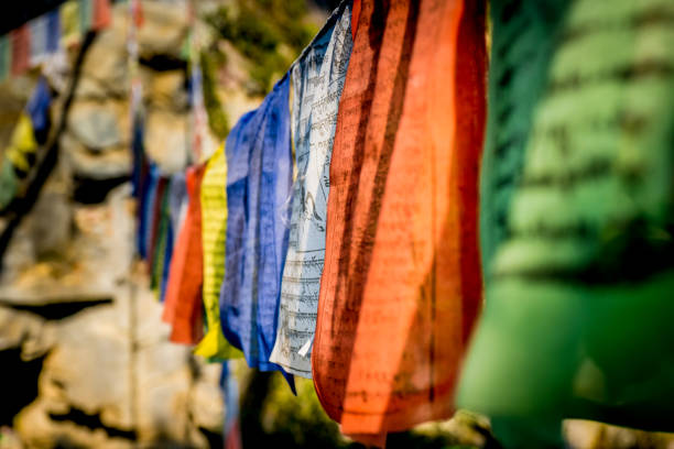 vue de plan rapproché des drapeaux tibétains de prière enfilés le long d’un sentier dans l’himalaya pour bénir la campagne environnante - bonpo photos et images de collection