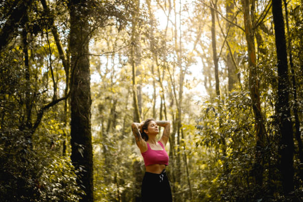 happy woman outdoors enjoying nature happy woman outdoors looking like she is enjoying the fragrant breeze of a blossoming tree floresta stock pictures, royalty-free photos & images