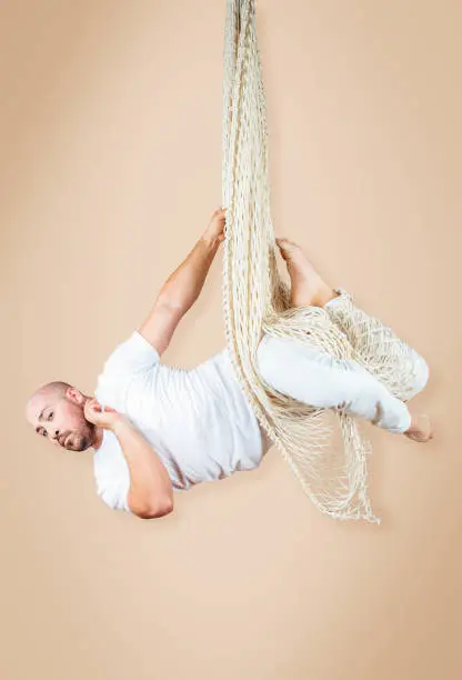 A man strikes a pose in a net during an aerial/acrobatic routine