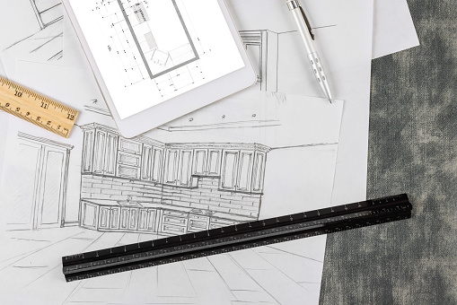 Designer makes a kitchen blueprint according to the drawing of an architectural project