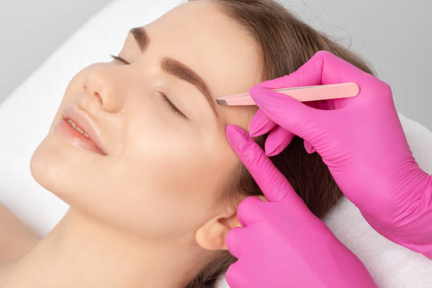 istock Makeup artist combs  and plucks eyebrows after dyeing in a beauty salon.Professional makeup and cosmetology skin care. 1316663214