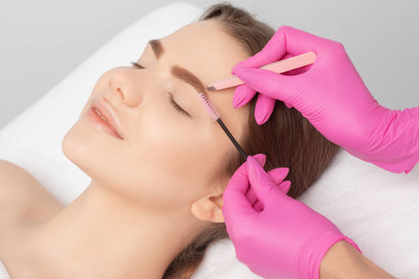 istock Makeup artist combs  and plucks eyebrows after dyeing in a beauty salon.Professional makeup and cosmetology skin care. 1316663215