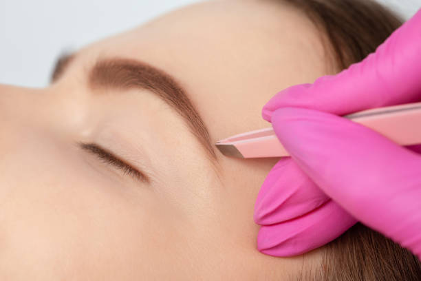 istock Makeup artist combs  and plucks eyebrows after dyeing in a beauty salon.Professional makeup and cosmetology skin care. 1316663261