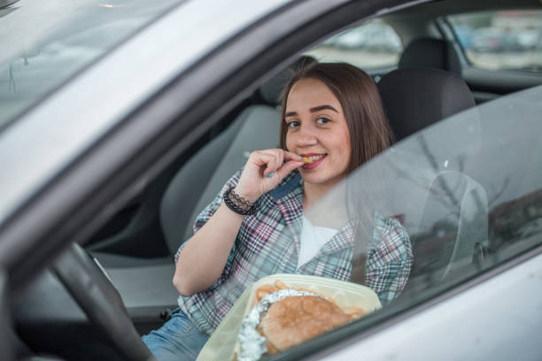 istock Smiling woman enjoys eating hamburger on a lunch break 1316664258