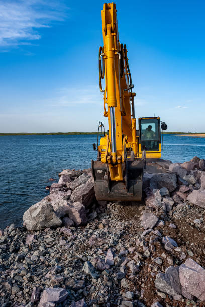 istock Excavator working on rocks at lake 1316664892