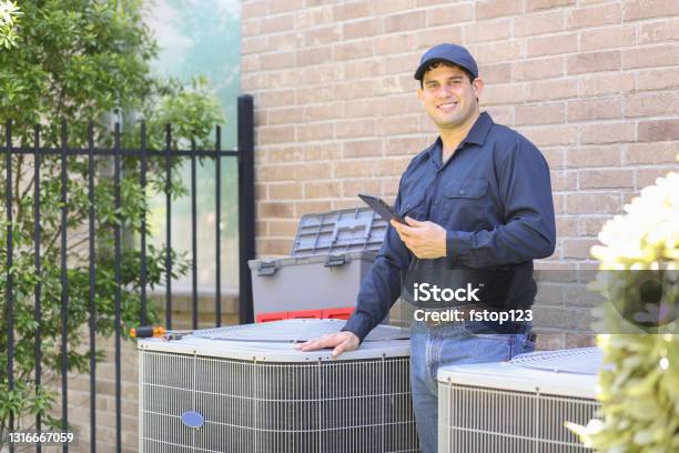 Latin Descent Blue Collar Air Conditioner Repairman At Work Stock Photo - Download Image Now
