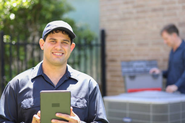 istock Multi-ethnic team of blue collar air conditioner repairmen at work. 1316667940
