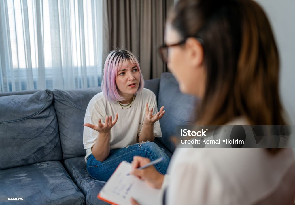 Hopeless Young woman talking with her Therapist Mental Health Professional Stock Photo