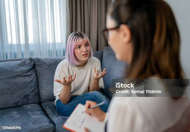 Hopeless Young Woman Talking With Her Therapist Stock Photo - Download Image Now - Mental Health Professional, Alcohol Abuse, Talking