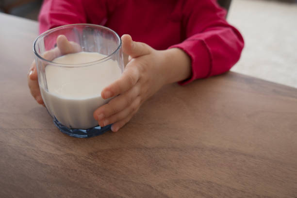 istock Cute little child drinking milk on table 1316668414